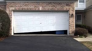 Garage door hanging crooked and off track viewed from outside